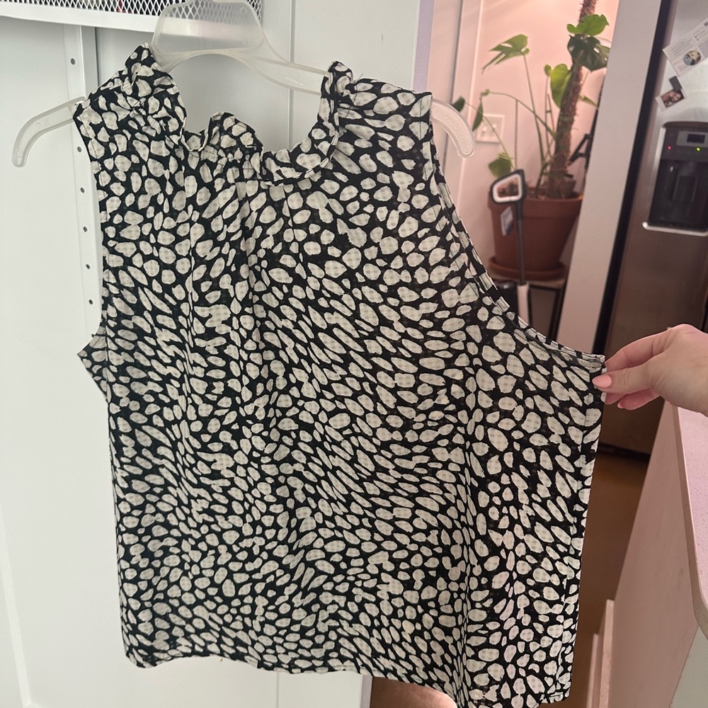 Sleeveless blouse with ruffled highneck